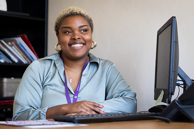 technology coordinator smiling at her desk